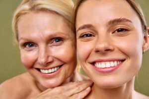 Two women of different ages smiling after a facelift in Andover, MA